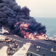 Flames erupt on the Forrestal’s flight deck moments after a malfunctioning rocket launched across the deck and struck an A-4 Skyhawk awaiting takeoff (US Navy)